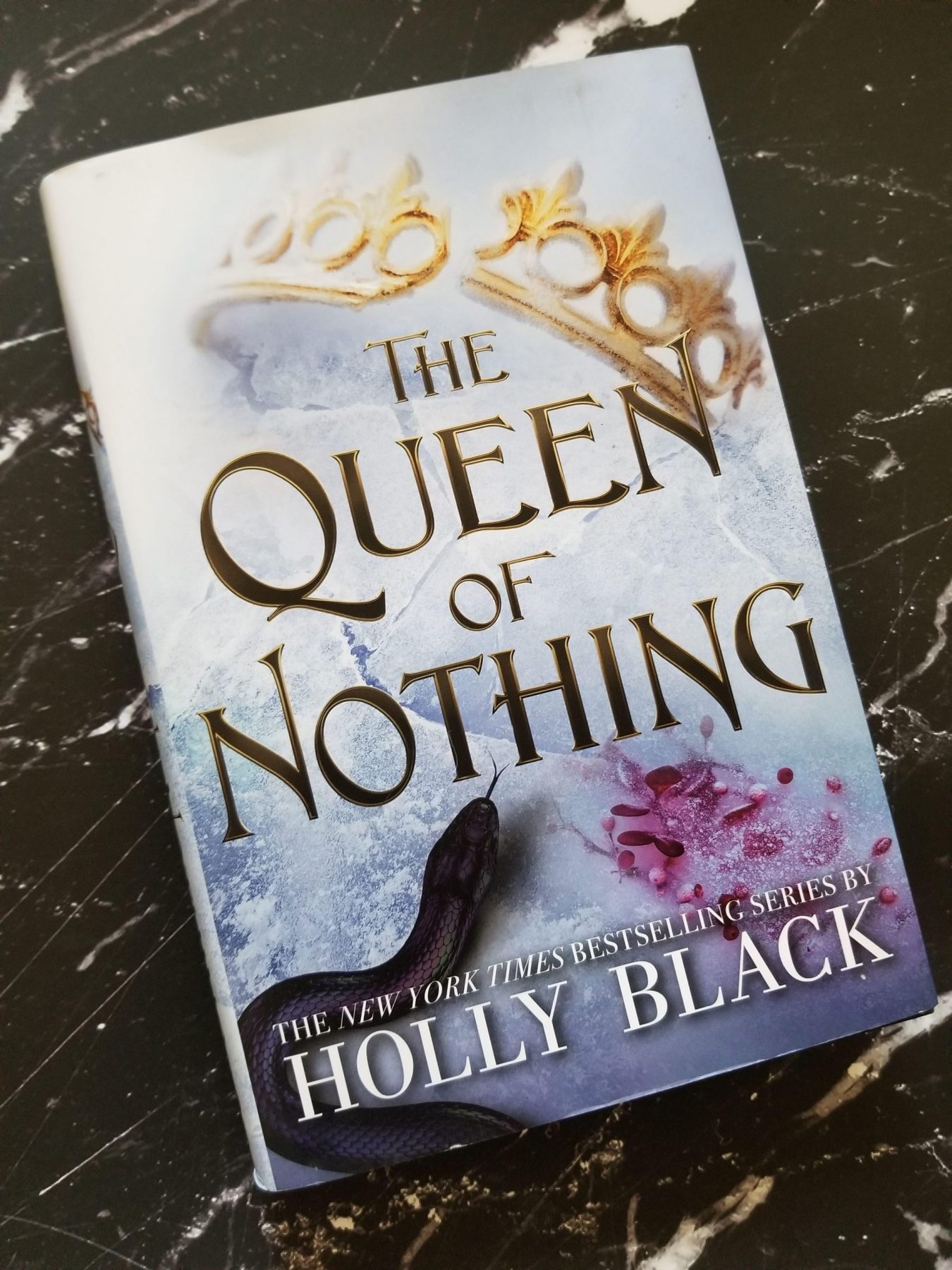 hardcover of the Queen of Nothing on a black marble background