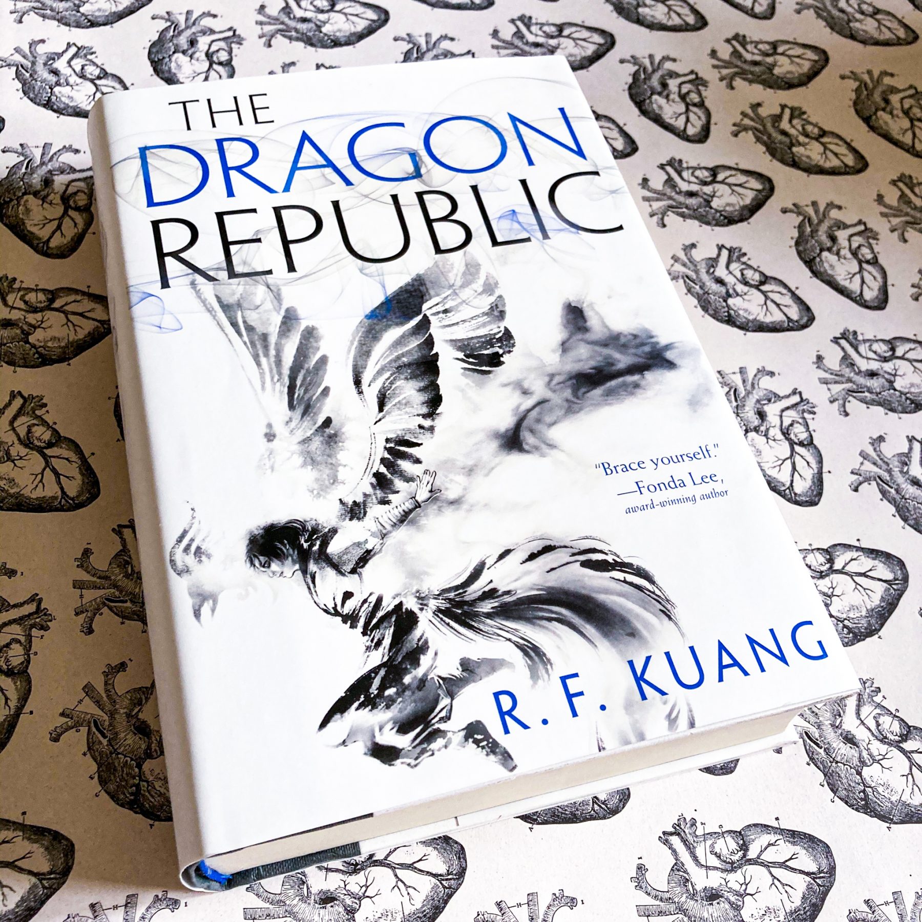 Hardcover of The Dragon Republic lays on top of decorative paper with anatomical heart drawings